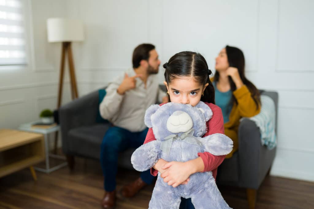 Sad young kid scared because her parents are fighting