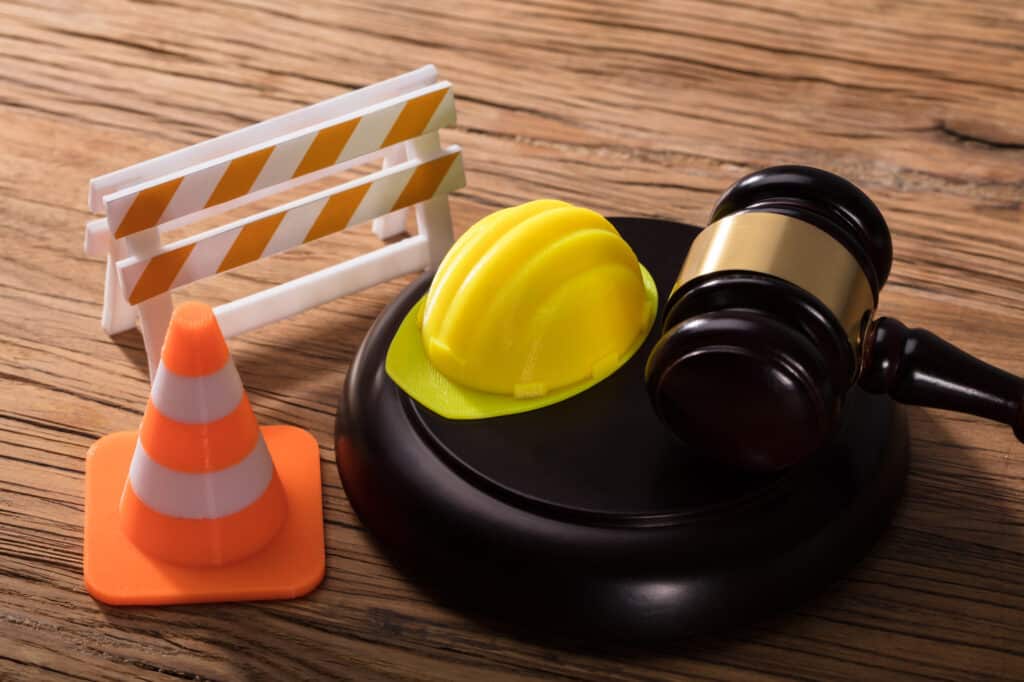 Gavel With Road Barrier, Hard Hat And Traffic Cone